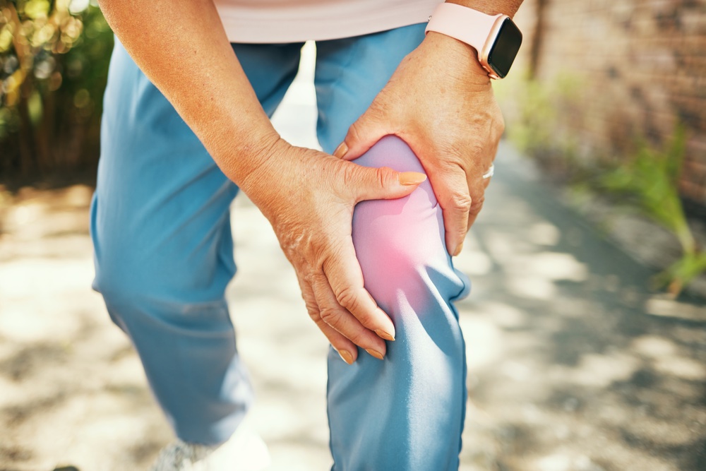 A Gentleman in blue pants experiencing knee pain looking for non-surgical therapies for knee pain