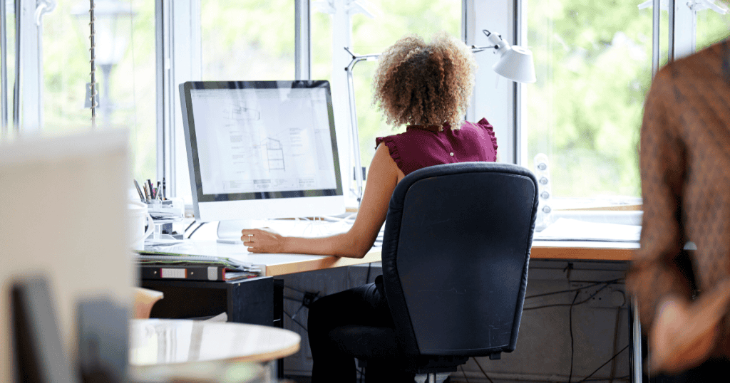 female working at her desk developing neck pain
